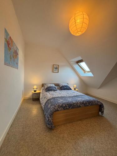 une chambre avec un grand lit dans un grenier dans l'établissement Maison Colette - Proche plage, à Saint-Malo