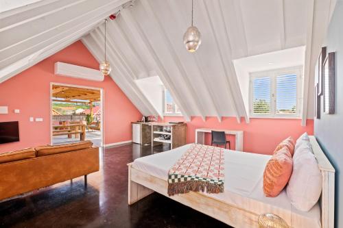 a bedroom with pink walls and a bed and a couch at BOHO Bohemian Boutique Hotel in Willemstad