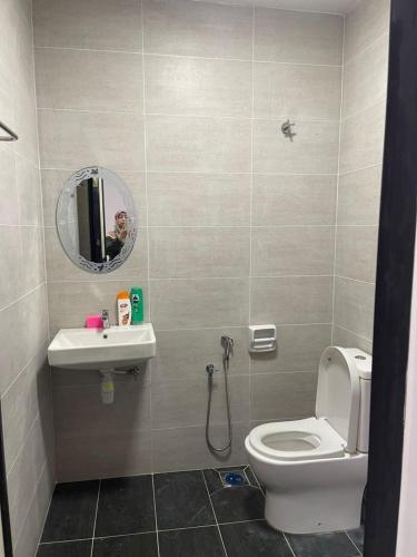 a bathroom with a toilet and a sink and a mirror at Homestay Idamanku in Shah Alam