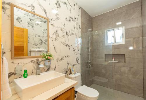 a bathroom with a sink and a toilet and a shower at Crown ll-3 Bedrooms-Pool-Close to everything! in San Felipe de Puerto Plata