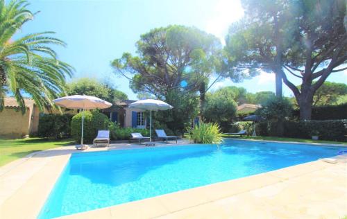 - une piscine avec 2 chaises longues et des parasols dans l'établissement Villa Sanderling - A 3 km de St-Tropez - Villa climatisée avec piscine privée, à Saint-Tropez