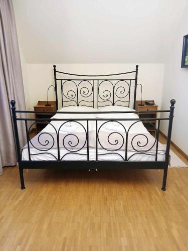 a black bed in a room with a wooden floor at Hotel Vesta Centrum Konferencyjno Wypoczynkowe in Jeleśnia