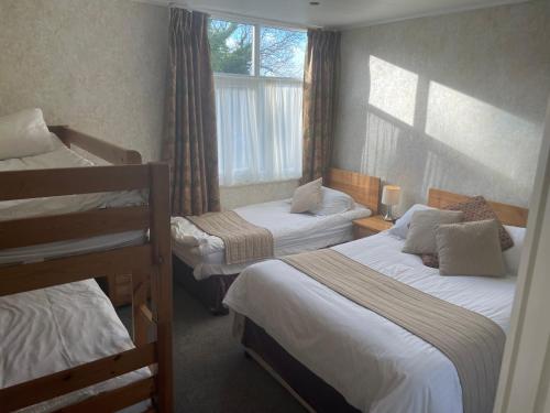 a bedroom with two bunk beds and a window at The Dog & Partridge Country Inn in Ashbourne