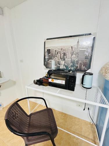 a white shelf with a microwave and a chair at DS Self service Apartment 02 in Phuket