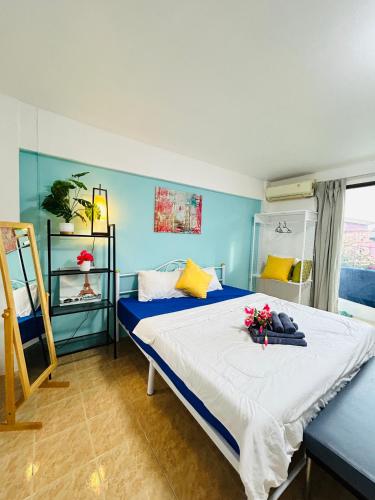 a blue bedroom with a bed with flowers on it at DS Self service Apartment 02 in Phuket