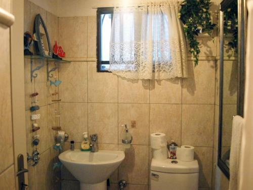 une salle de bain avec un lavabo et des toilettes et une fenêtre dans l'établissement Sylvia's House - a unique waterfront location, à Kokkari