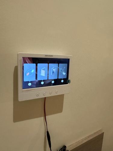 a television on a wall with a cord plugged into it at Nomad suites in Al Madinah