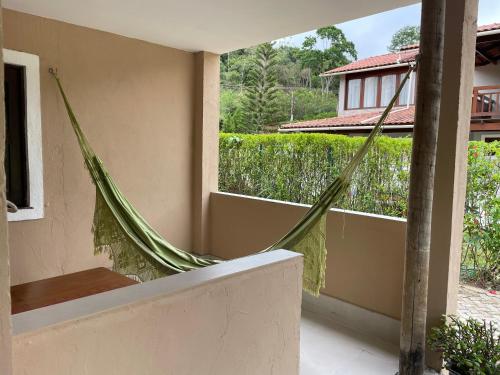 a hammock on the balcony of a house at Pousada Monteflor Guaramiranga-CE in Guaramiranga