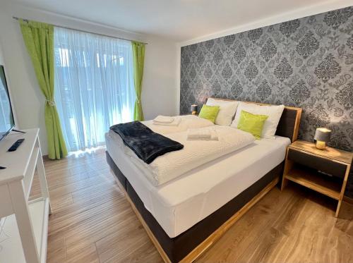 a bedroom with a large bed with green accents at Apartments Sunnseitn by Gerrit & Herfried in Krumpendorf am Wörthersee