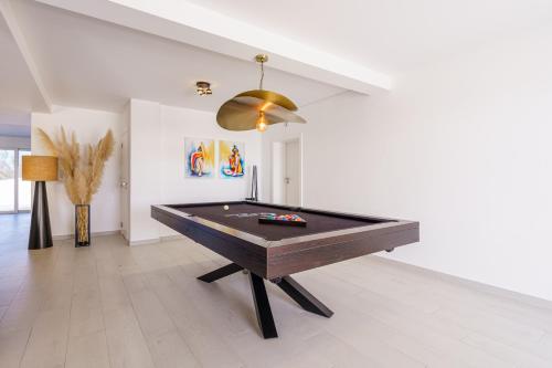 a pool table in a living room with a ceiling at Villa Carpe Diem, stunning villa with ocean view in Lourinhã