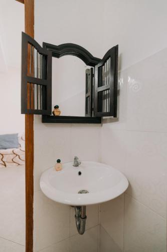 a bathroom with a sink and a mirror at Armaya Guest House in Gitgit