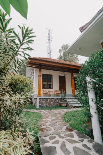 a house with a stone walkway in front of it at Armaya Guest House in Gitgit
