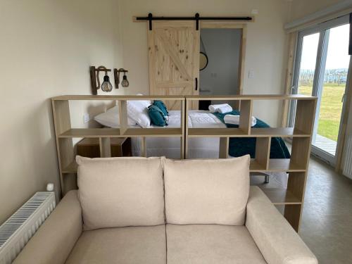 a living room with a couch and shelves with pillows at Cabañas Arte Brisa Patagonia in Puerto Natales