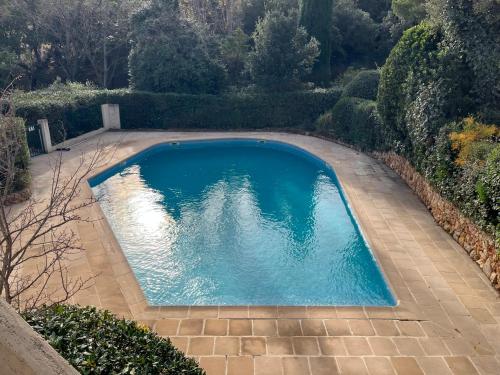 une piscine vide dans une cour arborée dans l'établissement Charmante Maison avec Piscine Commune - Résidence Les Logis du Boucharel, Confort et Détente, aux Issambres