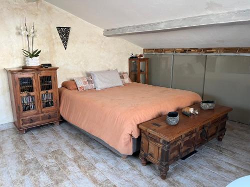 une chambre avec un grand lit et une table dans l'établissement Charmante Maison avec Piscine Commune - Résidence Les Logis du Boucharel, Confort et Détente, aux Issambres