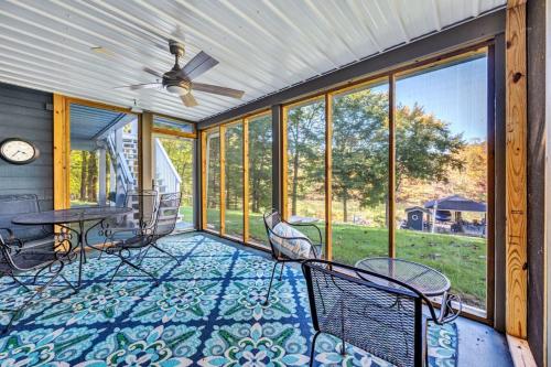 a screened in porch with chairs and a ceiling fan at Waterfront Lake House Ideal Dock for Boats, Swimming, Fishing in Moneta