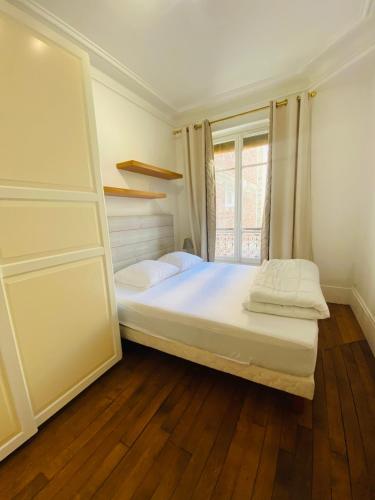 une chambre avec un grand lit et une fenêtre dans l'établissement Motte Picquet théâtre Paris, à Paris