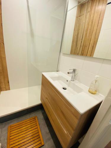 une salle de bain avec un lavabo, un miroir et une douche dans l'établissement Motte Picquet théâtre Paris, à Paris