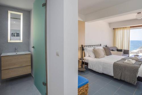 a bedroom with a bed and a bathroom with a sink at Ascuri Studio in Sissi