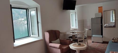 a living room with a table and chairs and a window at Villa Kamena in Kotor