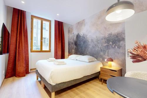 une chambre avec un lit et un tableau au mur dans l'établissement Studio Moderne en plein coeur de la Vieille Ville d'Annecy, à Annecy