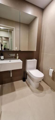 a bathroom with a toilet and a sink and a mirror at Melbourne CBD Southern Cross Collins St Skyline View Balcony in Melbourne