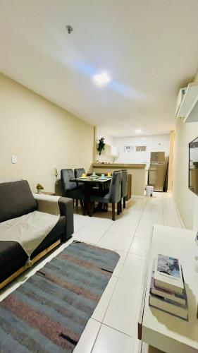 a living room with a couch and a table at Mandai Apartamentos in Cabo Frio