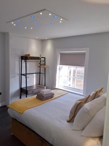 ein Schlafzimmer mit einem großen weißen Bett mit einem Fenster in der Unterkunft Casa De Niveles Near Beach Local Comfort in Weymouth