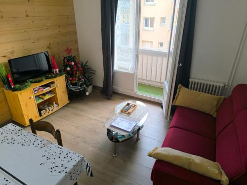 a living room with a couch and a table at T2 cosy proche des pistes in Briançon