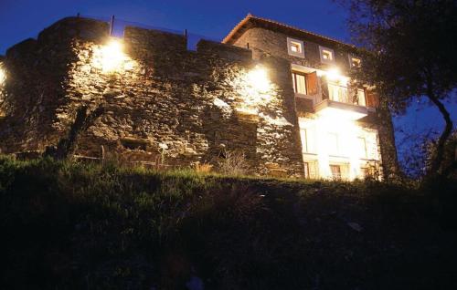 a large stone building with lights on it at night at Saronic Citadel Seaside villa in Salamís