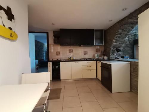 a kitchen with white cabinets and black appliances at Saronic Citadel Seaside villa in Salamís