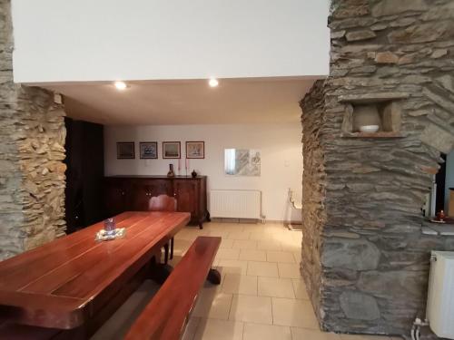 a dining room with a wooden table and a stone wall at Saronic Citadel Seaside villa in Salamís