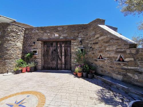 a stone building with a wooden door with potted plants at Saronic Citadel Seaside villa in Salamís