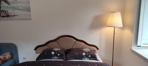a bed with a headboard and a lamp in a room at Villa Kamena in Kotor