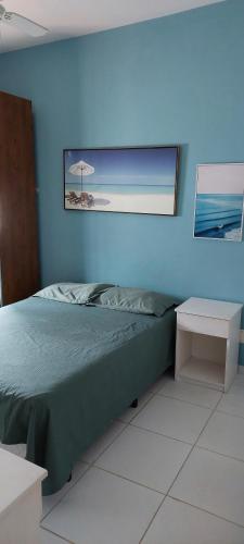 a bedroom with a bed and a picture of a beach at Suíte na Cobertura Enseada in Guarujá