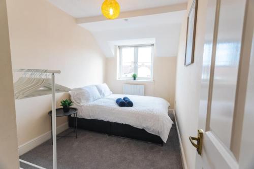 a small bedroom with a bed and a window at 9FWC, 2 Bedroom Apartment, Sleeps 4, 2 Double beds, Parking in Swindon