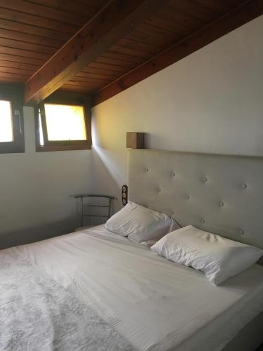 a bedroom with a white bed with two pillows at Casas del Mar in Cadaqués