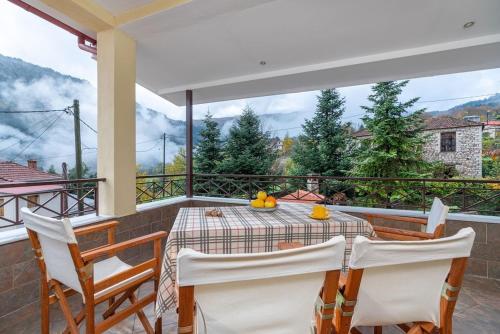 a dining room with a table and chairs on a balcony at Villa Kleino - 30 min from Meteora in Kalabaka