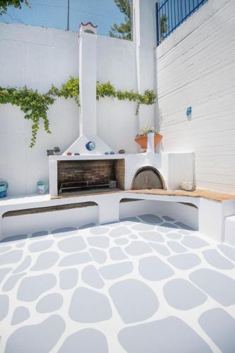 a patio with a white floor with a fireplace at Blue Dream Seaside Villa with superb sea views in Kymi