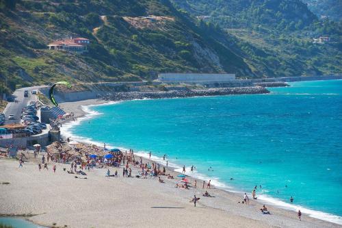 a group of people on a beach near the ocean at Blue Dream Seaside Villa with superb sea views in Kymi