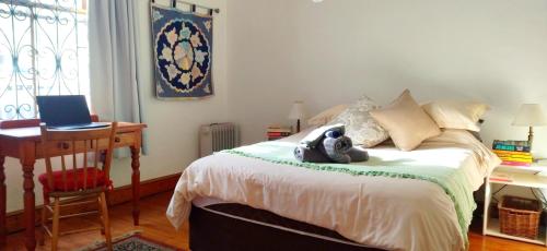 a bedroom with a bed with a teddy bear on it at Victorian Woodstock in Cape Town