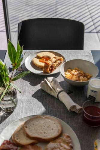 a table with plates of bread and a bowl of food at Bfour in Pergine Valsugana