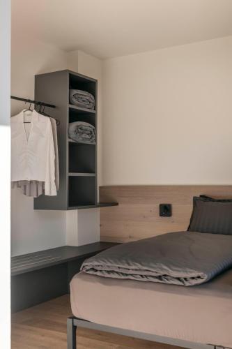 a bedroom with a bed and a shelf with clothes at Bfour in Pergine Valsugana