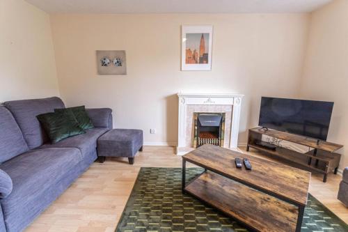 a living room with a couch and a tv at Thorley Apartment in North Swindon, Sleeps 4 in 2 bedrooms, Long Stay Disc, Parking in Swindon