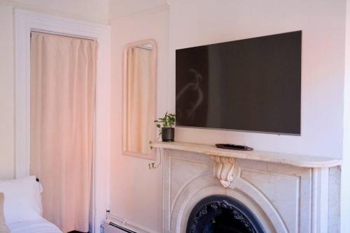 Uma TV ou centro de entretenimento em The West Village Gem