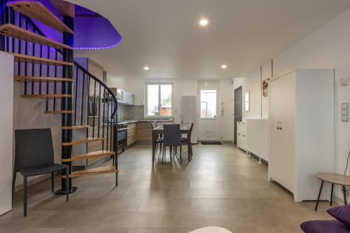a living room and kitchen with a spiral staircase at La maison du centre in Vendôme