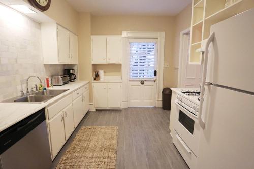 a white kitchen with a sink and a refrigerator at Oglethorpe Manor Main House in Savannah