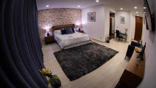 a bedroom with a large bed with a black rug at Hotel Tanino in Ezequiel Montes