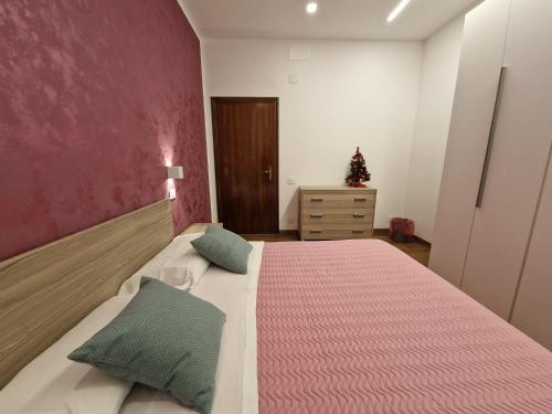 a bedroom with a large bed with a pink wall at B&B Casa Ciarpella in Montegranaro