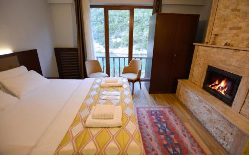 a bedroom with a bed and a fireplace at Hill River Hotel in Agva